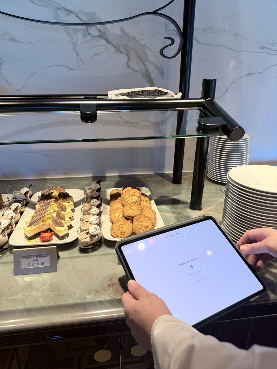 Tablet met buffetinformatie naast gerechten
